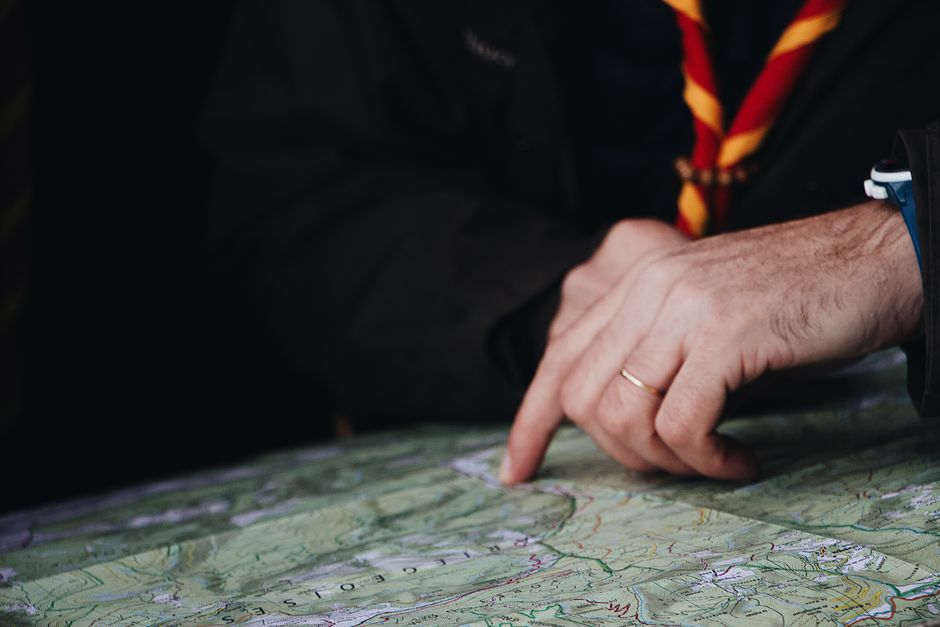 Close-up of a hand pointing to a map, suggesting a travel or navigation theme.